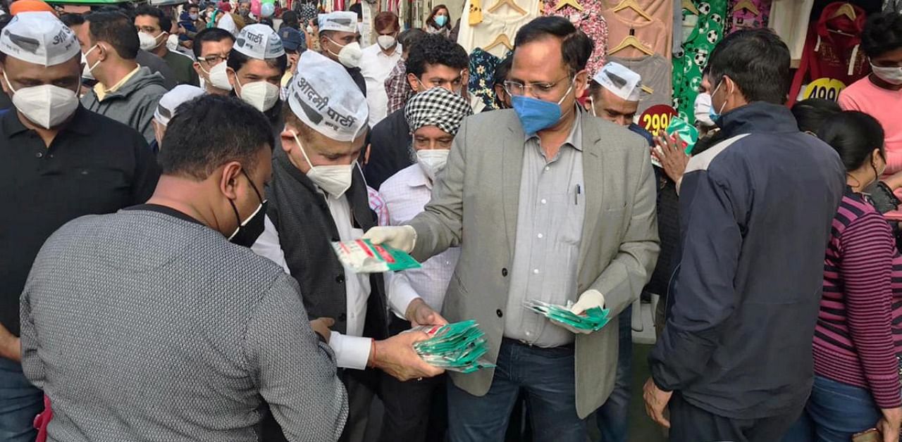 Delhi Health Minister Satyendar Jain distributes mask during a Covid-19 awareness campaign, in New Delhi. Credit: PTI/@SatyendarJain.