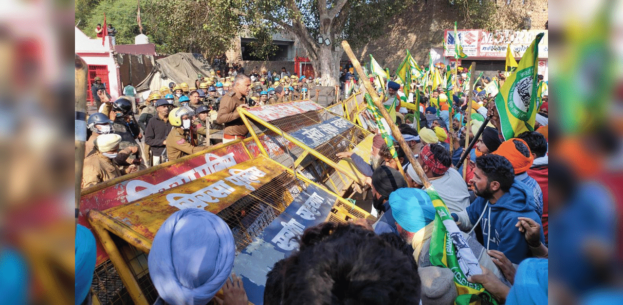 BKU (Ugrahan) activists break police barricades as they arrive at the Dabwali border of Punjab and Haryana border during their 'Delhi Chalo' protest against Centre's new farm laws, in Sirsa district, Friday, Nov. 27, 2020. Credit: PTI Photo