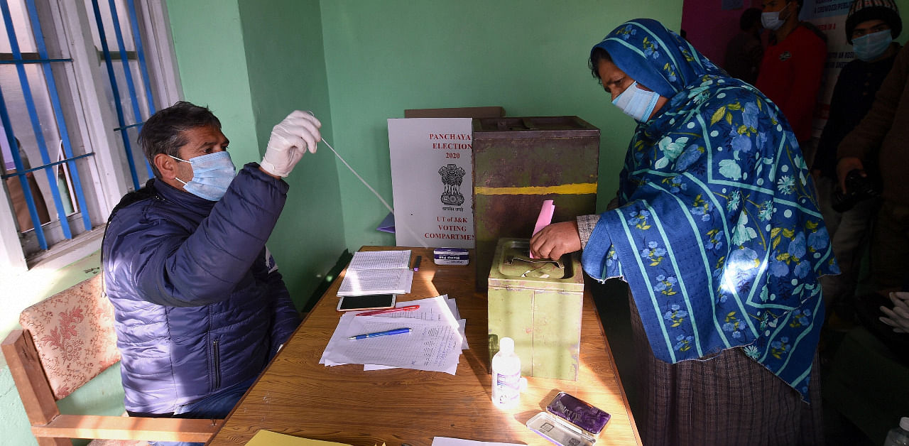  A woman casts her vote for the first phase of the District Development Council (DDC) elections, at Gund in Ganderbal district of central Kashmir. Credit: PTI Photo