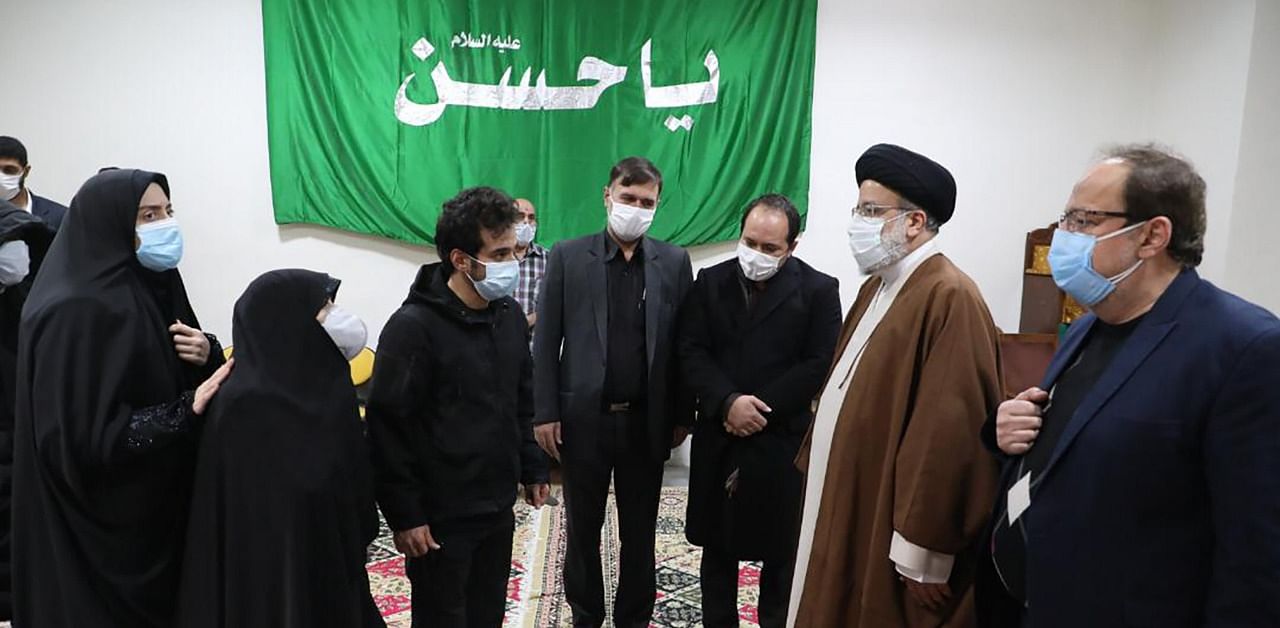 Iran's Judiciary Chief Ayatollah Ebrahim Raisi (2nd-R) pays respects to the body of slain scientist Mohsen Fakhrizadeh among his family, in the capital Tehran on November 28, 2020. Credit: AFP Photo