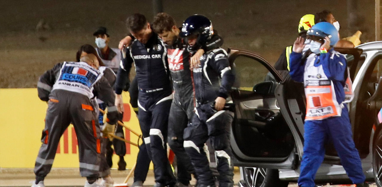 Haas' Romain Grosjean is helped to walk away by medical officers after crashing out at the start of the race. Credit: Reuters Photo