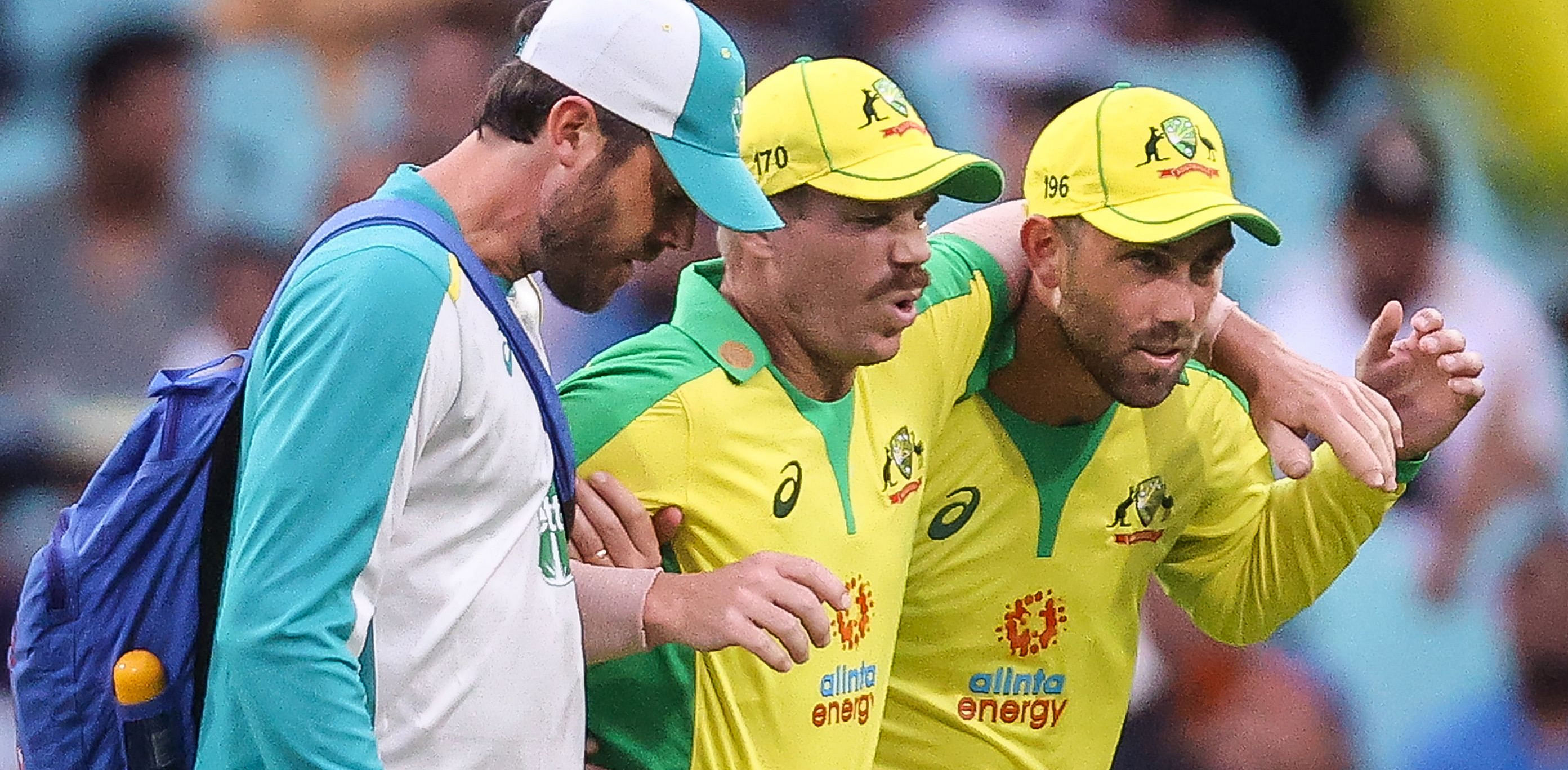 Australia's David Warner (C) is assisted by team mate Glenn Maxwell (R) and a trainer as he leaves the field after he suffered an injury during the one-day cricket match against India at the Sydney Cricket Ground (SCG). Credit: AFP