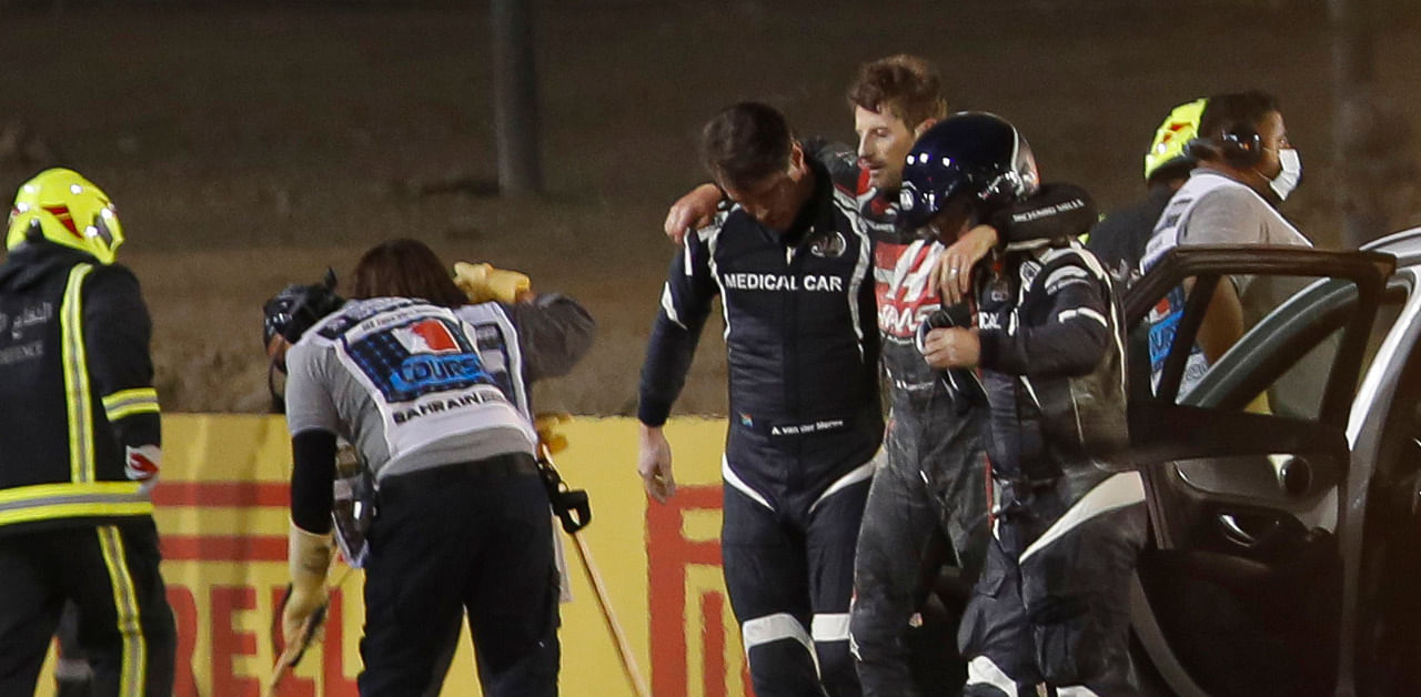 Stewards and medics attend to Haas F1's French driver Romain Grosjean after a crash at the start of the Bahrain Formula One Grand Prix at the Bahrain International Circuit. Credit: AFP Photo