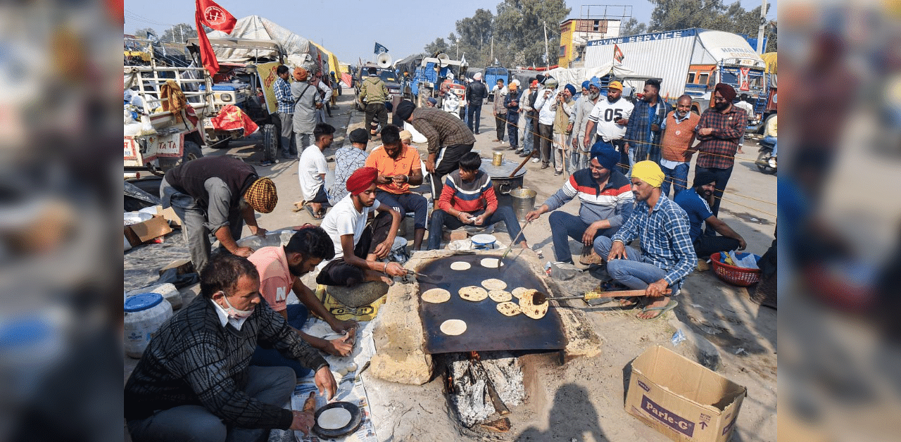 Farmers cook 'chapati' at the Singhu border as part of their 'Delhi Chalo' protest against Centre's new farm laws, in New Delhi, Monday, Nov. 30, 2020. Credit: PTI Photo