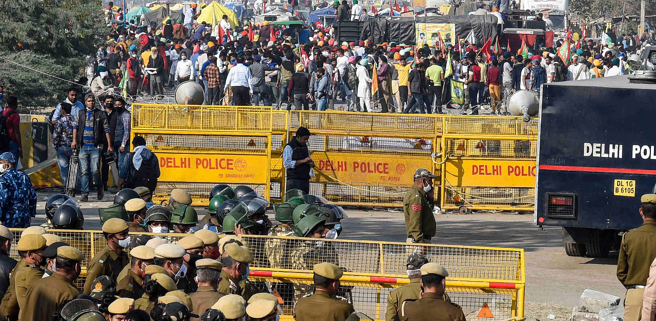 Police stand guard near a barricade as farmers protest at Singhu border during their 'Delhi Chalo' march against the Centre's farm reform laws. Credit: PTI Photo