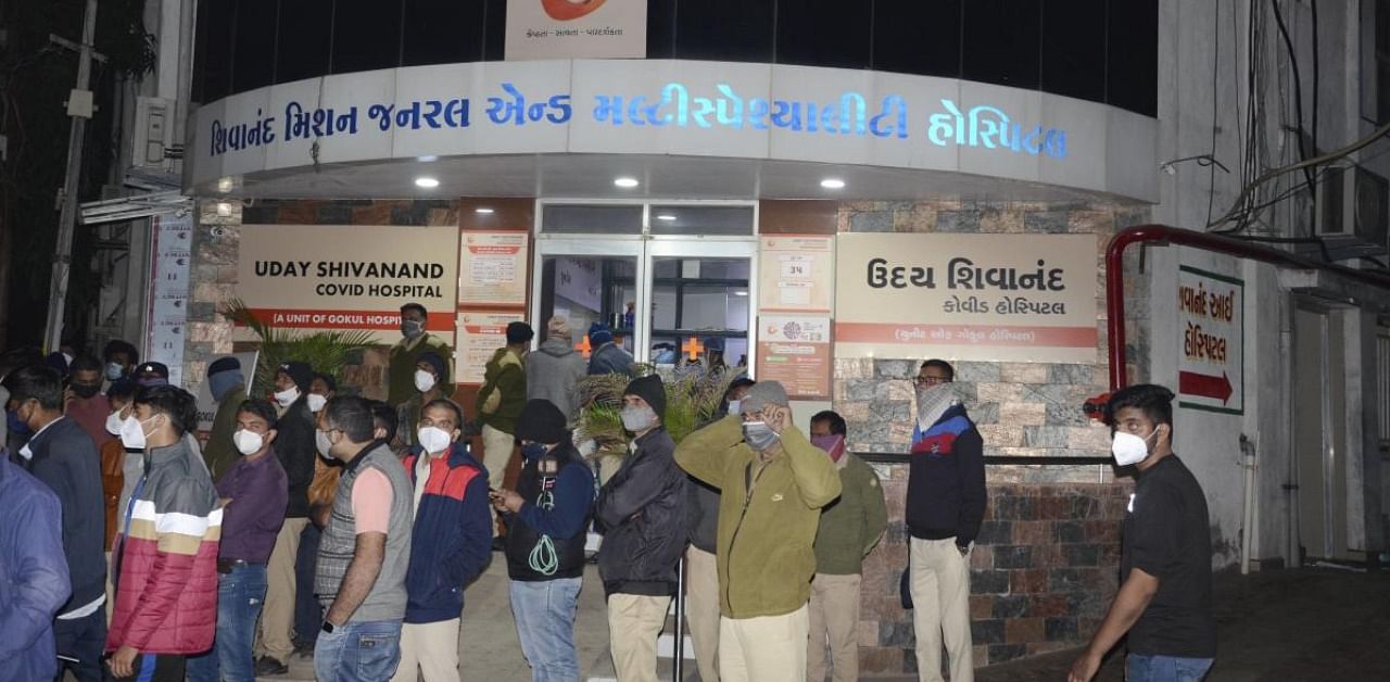 Locals outside the designated Covid-19 hospital after a fire broke out in its ICU, in Rajkot. Credit: PTI.