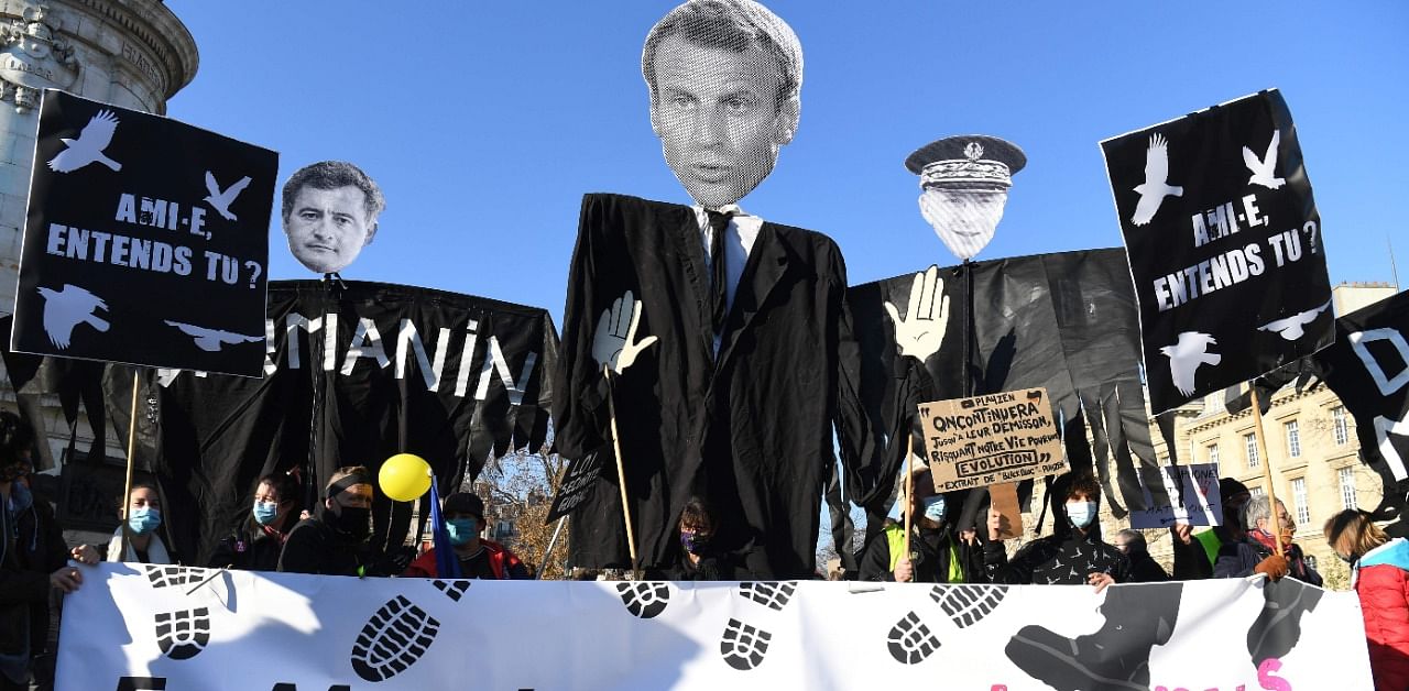 Demonstrators hold effigies of French President Emmanuel Macron, French Interior Minister Gerald Darmanin and Paris police prefect Didier Lallement on the Place de la Republique in Paris. Credit: AFP Photo