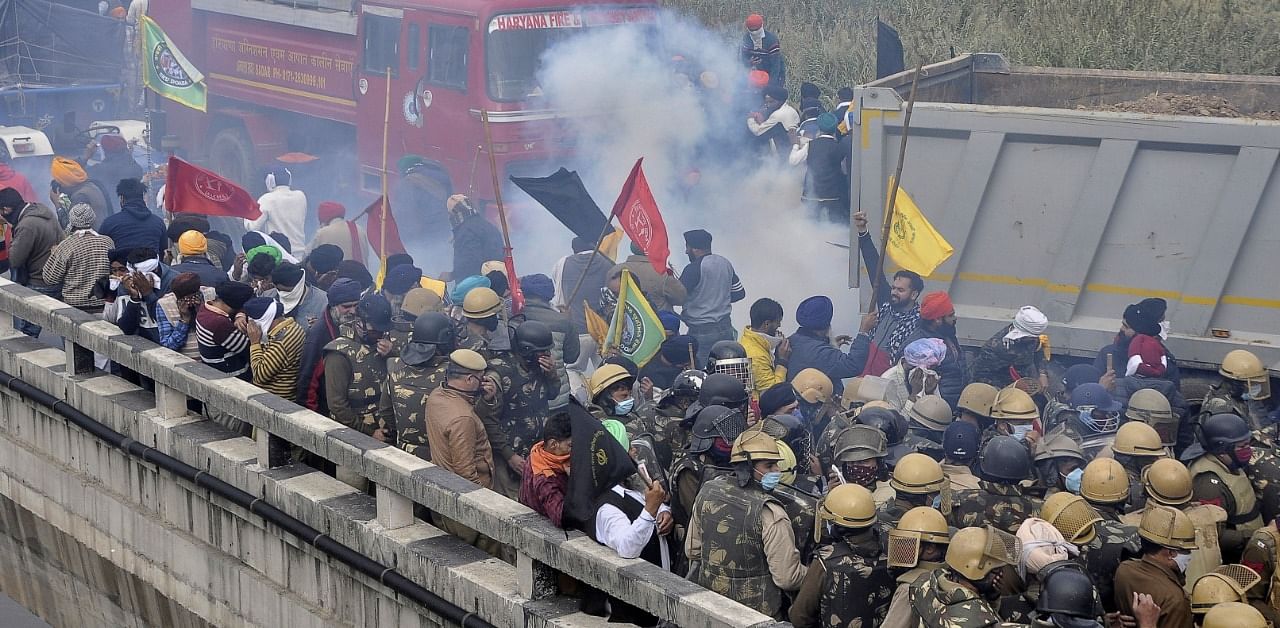 Farmers run away as police fire tear smoke shells to disperse the protesting farmers as they try to march to Delhi to protest against farm bills passed by India's parliament, near Ambala. Credit: Reuters Photo