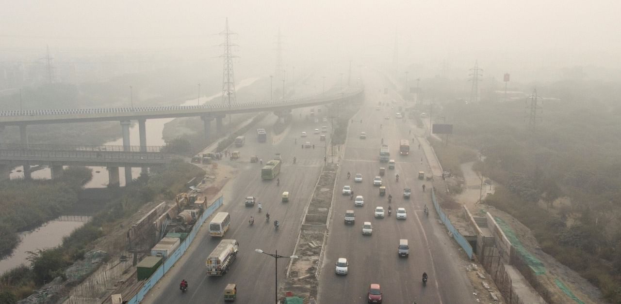 Traffic moves along a highway shrouded in smog in New Delhi. Credit: Reuters Photo