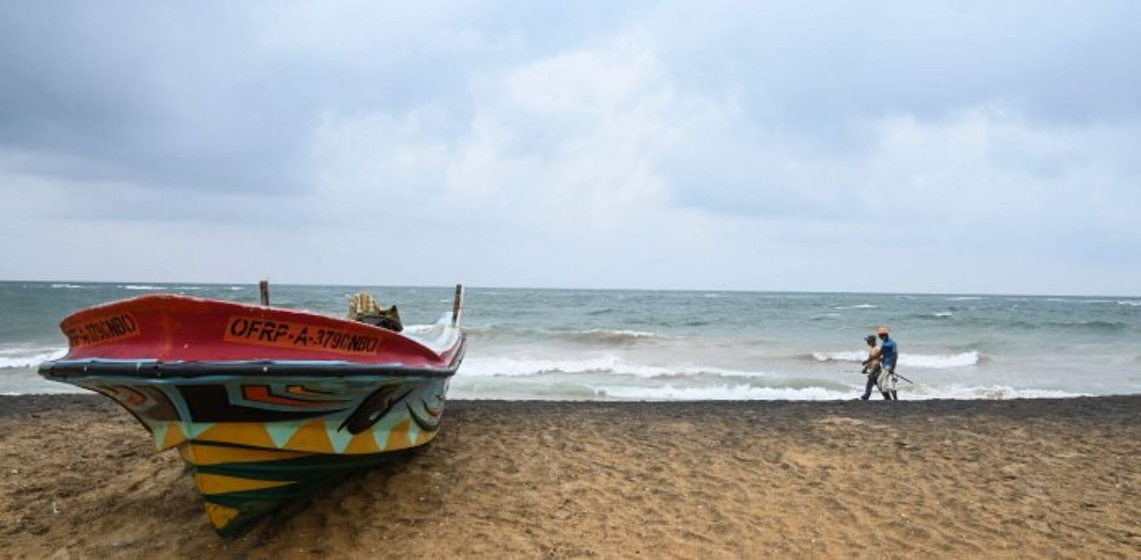 Fishermen walk along Mount Lavinia beach on the outskirts of Colombo. Credit: AFP Photo