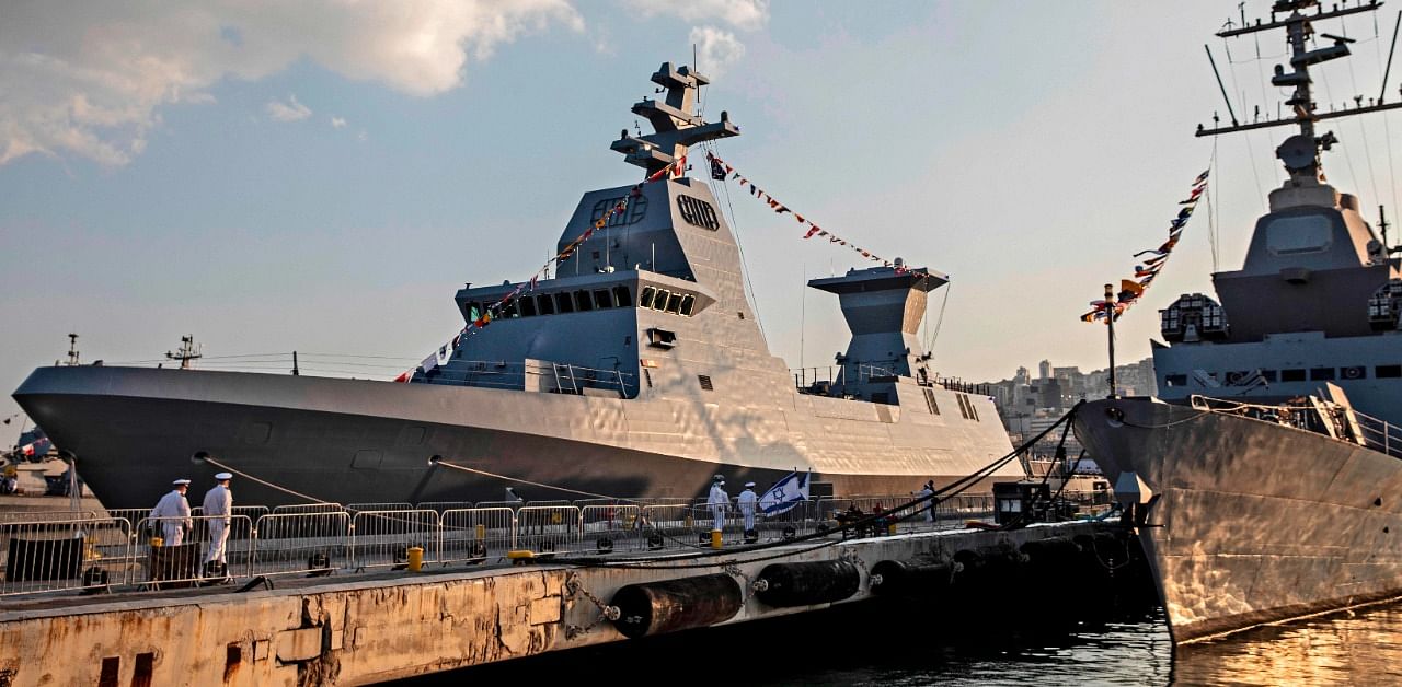 Israeli sailors walk on a pier near the first of four new German-built Saar 6 naval vessels (L) purchased by the navy, in the northern Haifa city naval base. Credit: AFP Photo