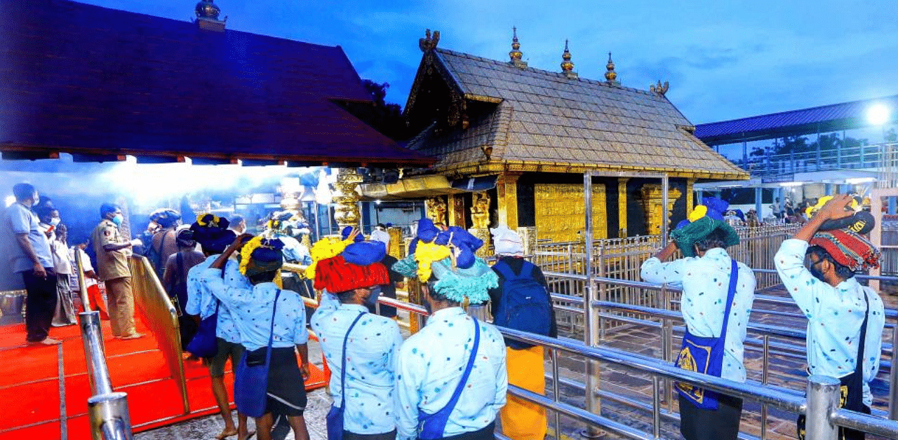 Devotees maintain social distance while standing in queues to offer prayers at Lord Ayyappa temple. Credit: PTI File Photo