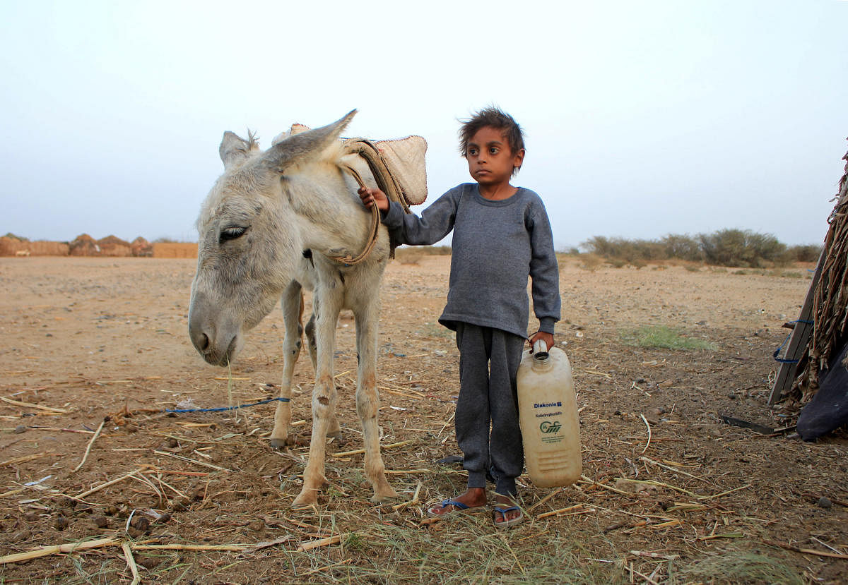 Malnourished boy Hassan Merzam Muhammad stands by a donkey near his family's hut in Abs district of Hajjah province, Yemen. Credit: Reuters photo. 