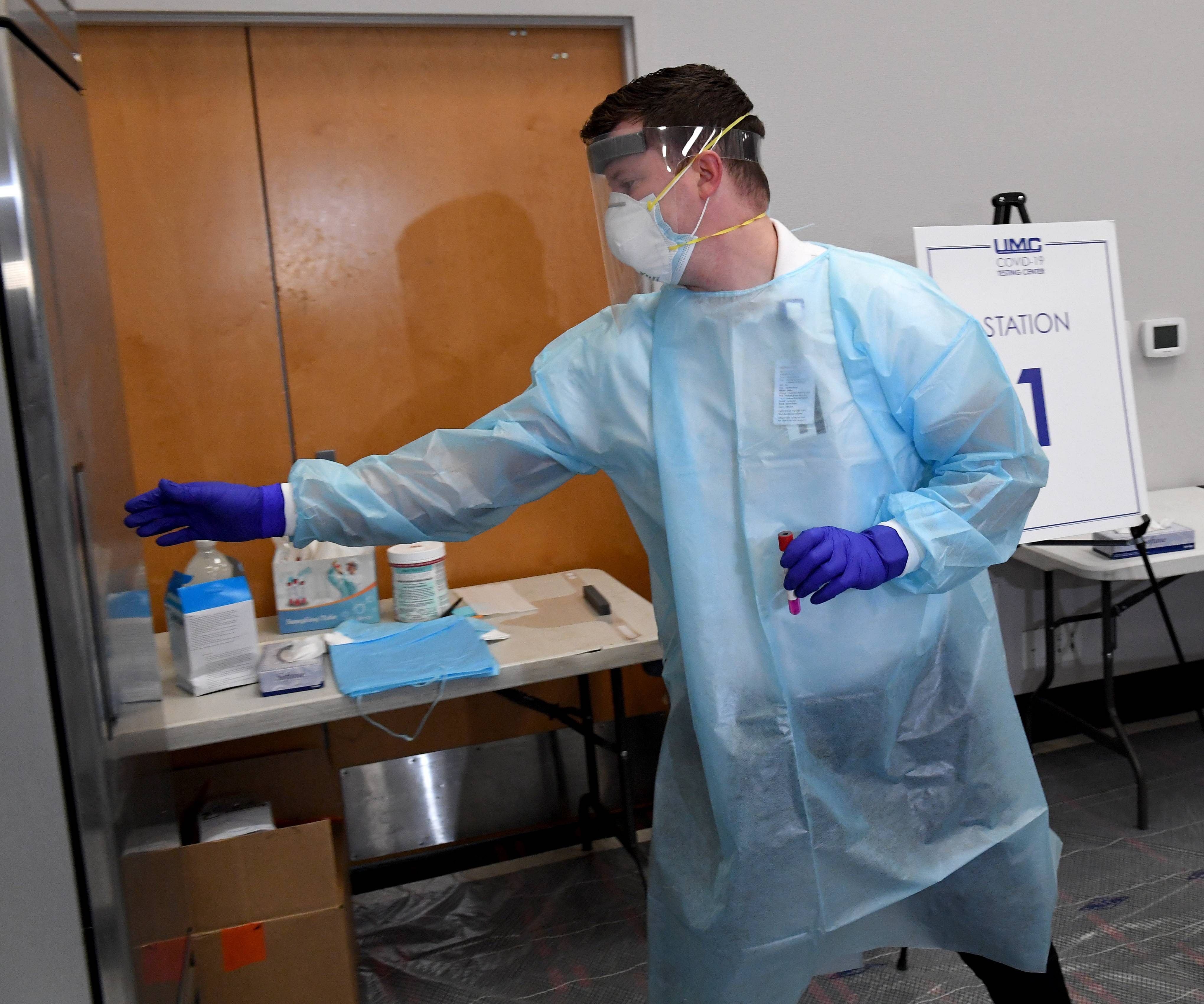University Medical Center of Southern Nevada supervisor Isaac Nielson puts a coronavirus (COVID-19) specimen sampling tube into a refrigerator during a preview of a testing site at the Stan Fulton - International Gaming Institute Building at UNLV on November 30, 2020 in Las Vegas, Nevada. The state set its two highest single-day COVID-19 case records and surpassed 150,000 total cases last week. Nevada has seen a sharp upward climb in the test positivity rate since the end of October, which has now grown to more than 17 percent. Clark County and UMC are operating the new site, which has separate areas for people who arrive with and without symptoms of COVID-19, in partnership with the Nevada National Guard and University Police Services. Credit: Getty Images/AFP