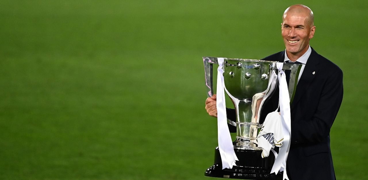 In this file photo taken on July 16, 2020 Real Madrid's French coach Zinedine Zidane celebrates with the trophy after winning the Liga title after the Spanish League football match between Real Madrid CF and Villarreal CF. Credit: AFP Photo