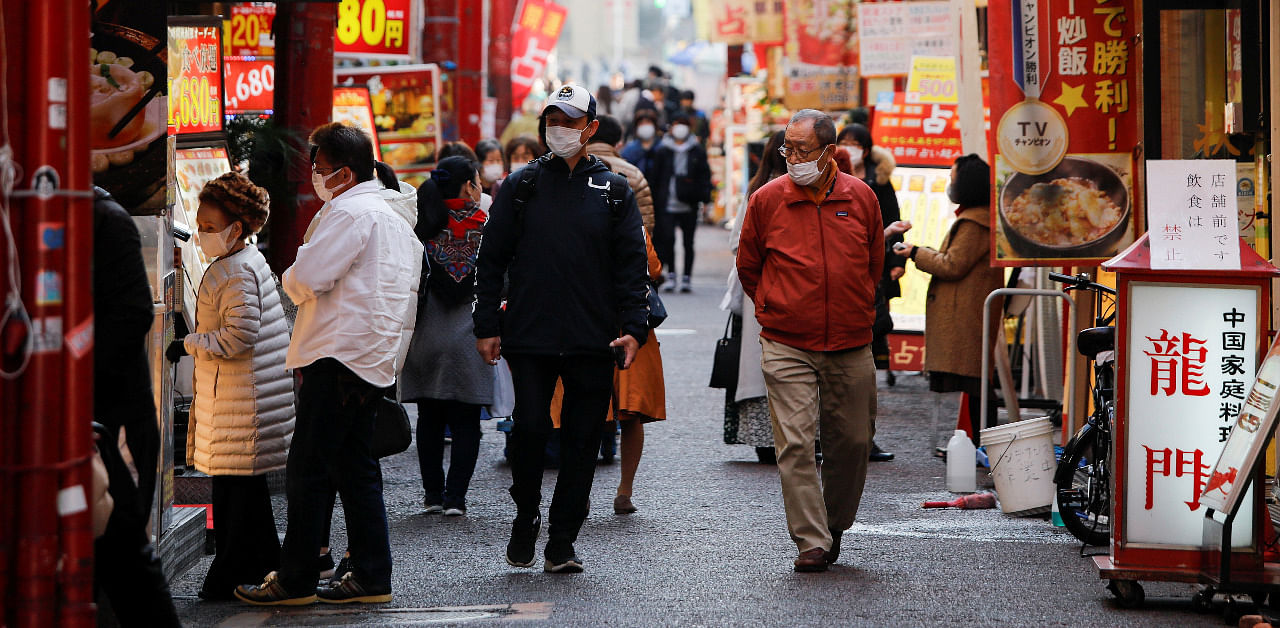 Passersby wearing protective face masks walk on the street at Yokohama's China town, amid the coronavirus disease in Japan. Credit: Reuters Photo