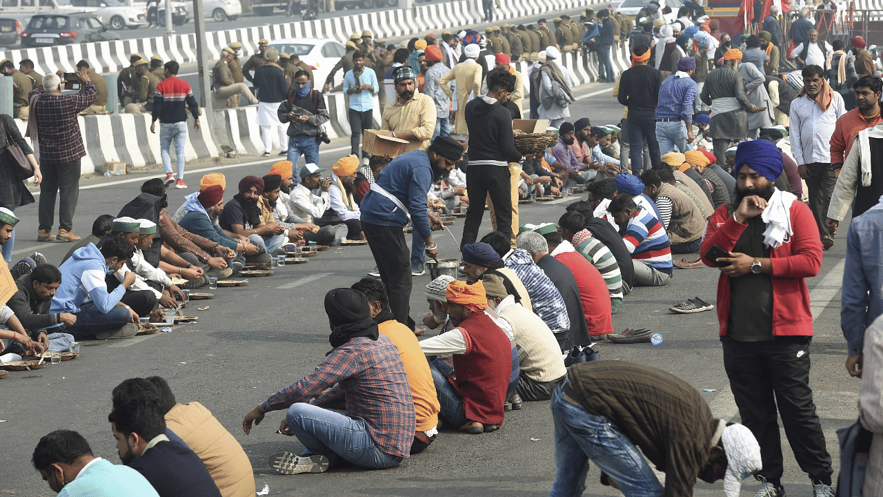 Volunteers serve 'langar' to farmers' protesting at Delhi-UP border over Centre's farm reform laws, in New Delhi. Credit: PTI Photo