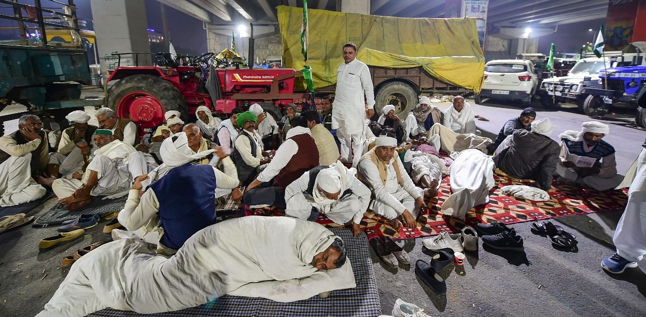  Farmers take rest during their 'Delhi Chalo' protest march against the new farm law, at Ghazipur Delhi-UP border in New Delhi. Credit: PTI Photo