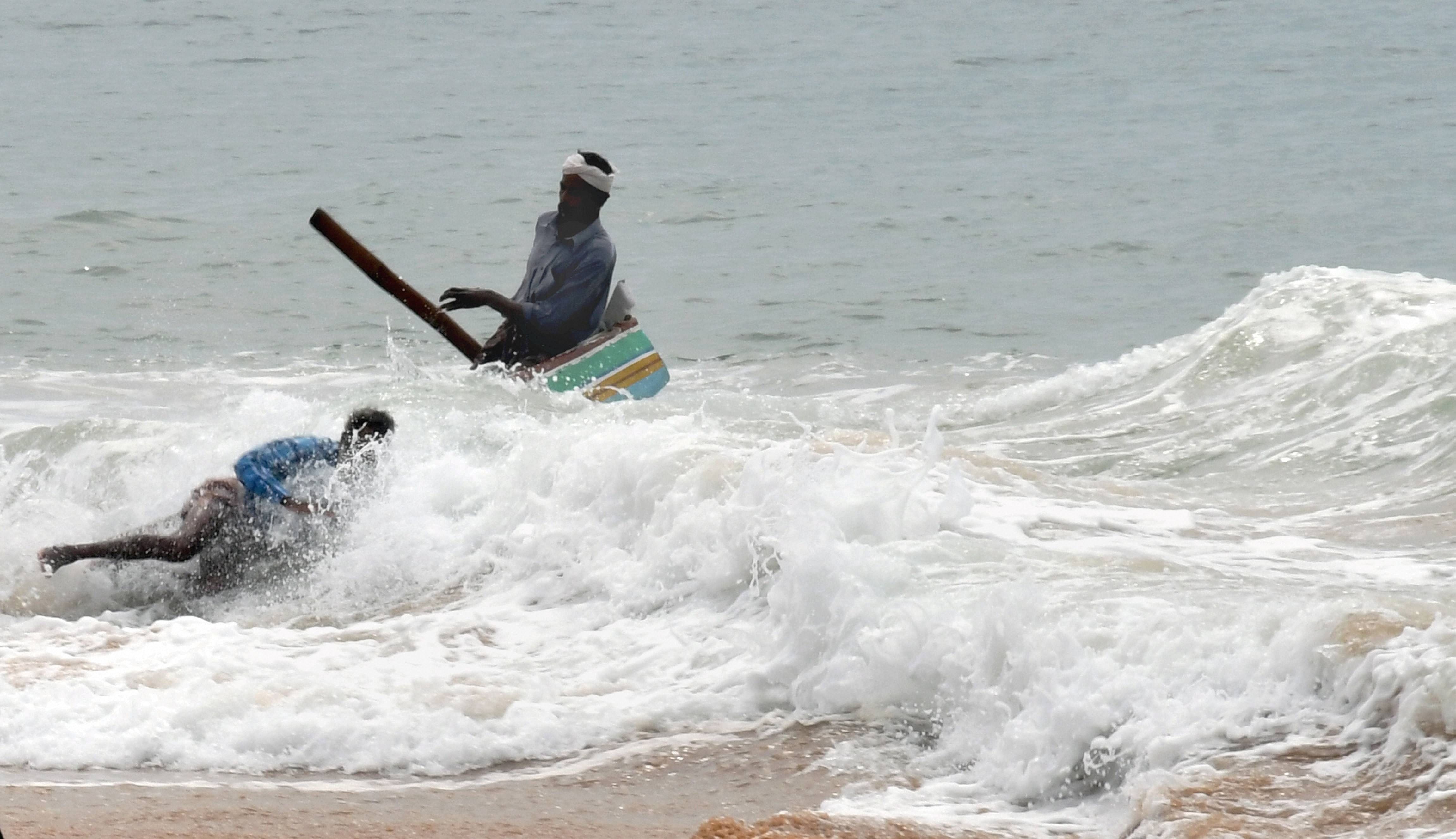 Fishermen struggle to bring their boat to the shore due to rough sea, ahead of Cyclone Burevi, at Pozhikkara beach in Thiruvananthapuram, Friday, Dec 4, 2020. Credit: PTI Photo