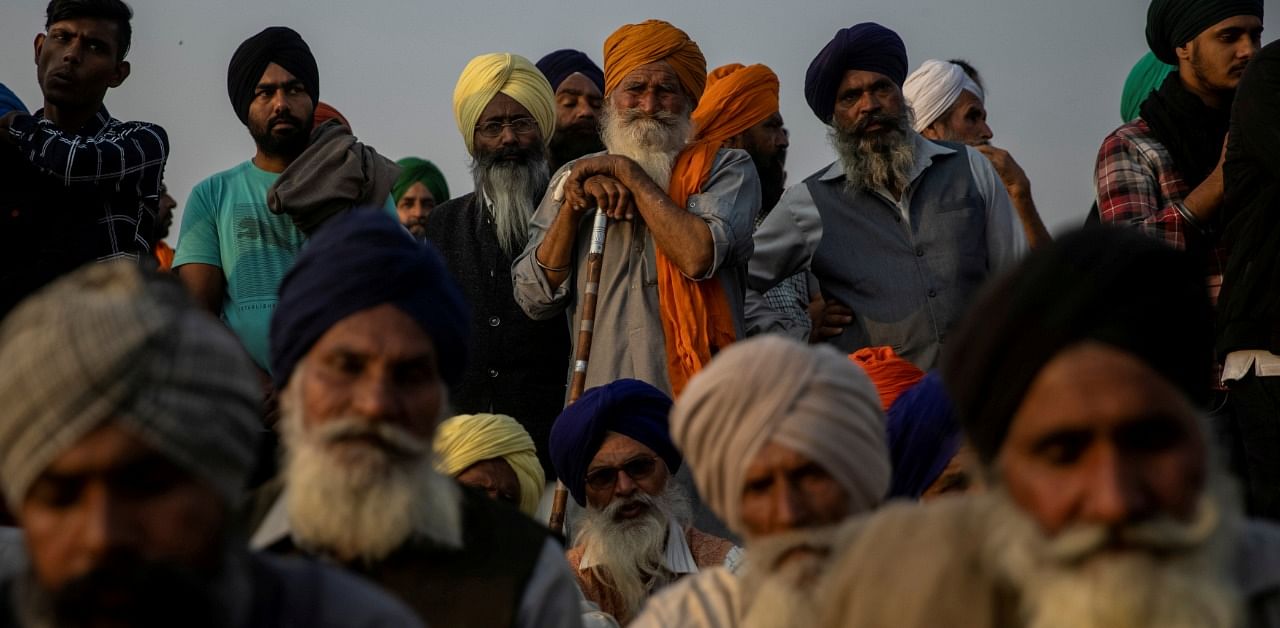 Farmers listen to a speaker as they attend a protest against the newly passed farm bills at Singhu border near Delhi. Credit: Reuters Photo