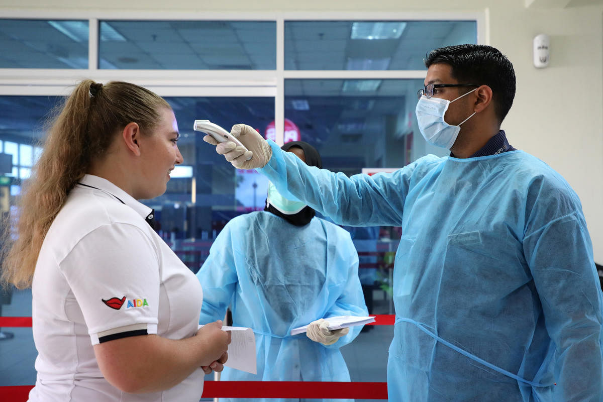 A Malaysian health quarantine officer checks the temperature of a passenger as a precautionary measure at a cruise ship terminal, following the outbreak of the coronavirus in China, in Port Klang, Malaysia February 13, 2020. (Reuters photo)