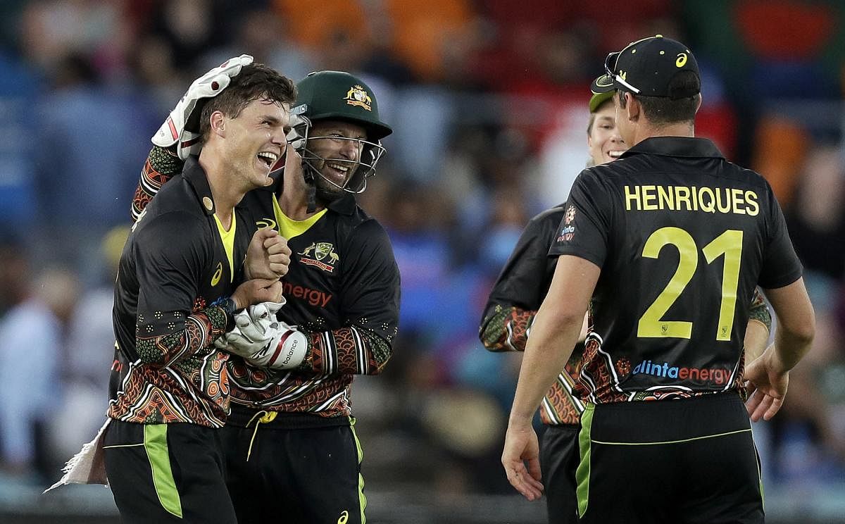 Australia's Mitchell Swepson, left, is congratulated by teammates after taking the wicket of India's Virat Kohli for 9 runs during their T20 international cricket match at Manuka Oval. Credit: AP