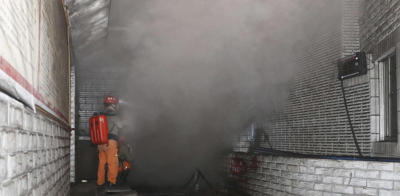 Rescue workers gauge the density of carbon monoxide in a coal mine. Credit: AP/PTI Photo