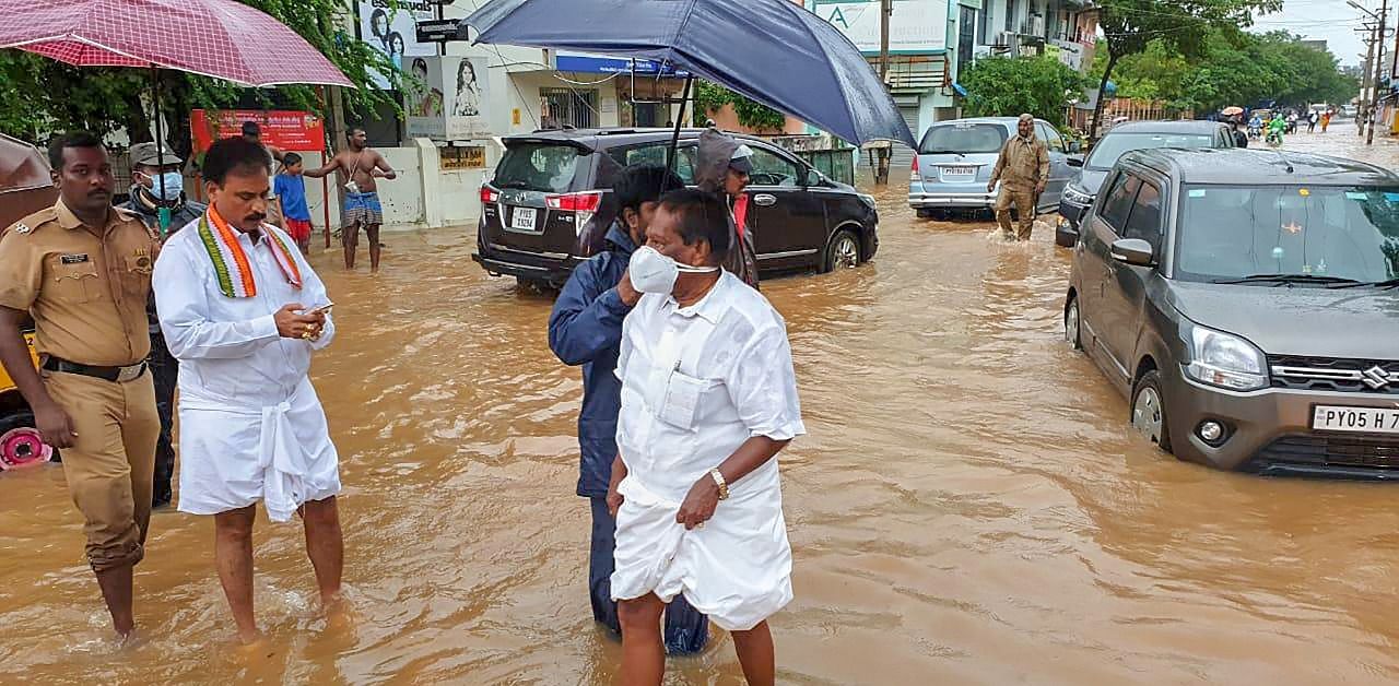 Puducherry Chief Minister V Narayanasamy wades through a flooded street to supervise the steps taken by the municipality workers to pump out the water. Credt: PTI Photo