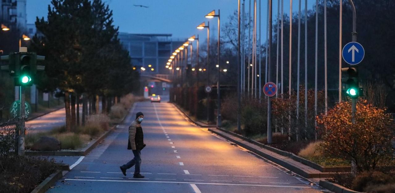 A man crosses the street as people leave their home area in the Gallus district in Frankfurt am Main, western Germany. Credit: AFP Photo
