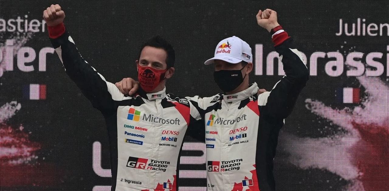 French driver Sebastien Ogier and his co-driver Julien Ingrassia celebrate on the podium after winning the FIA World Rally Championship at the Autodromo Nazionale circuit in Monza. Credit: AFP photo.