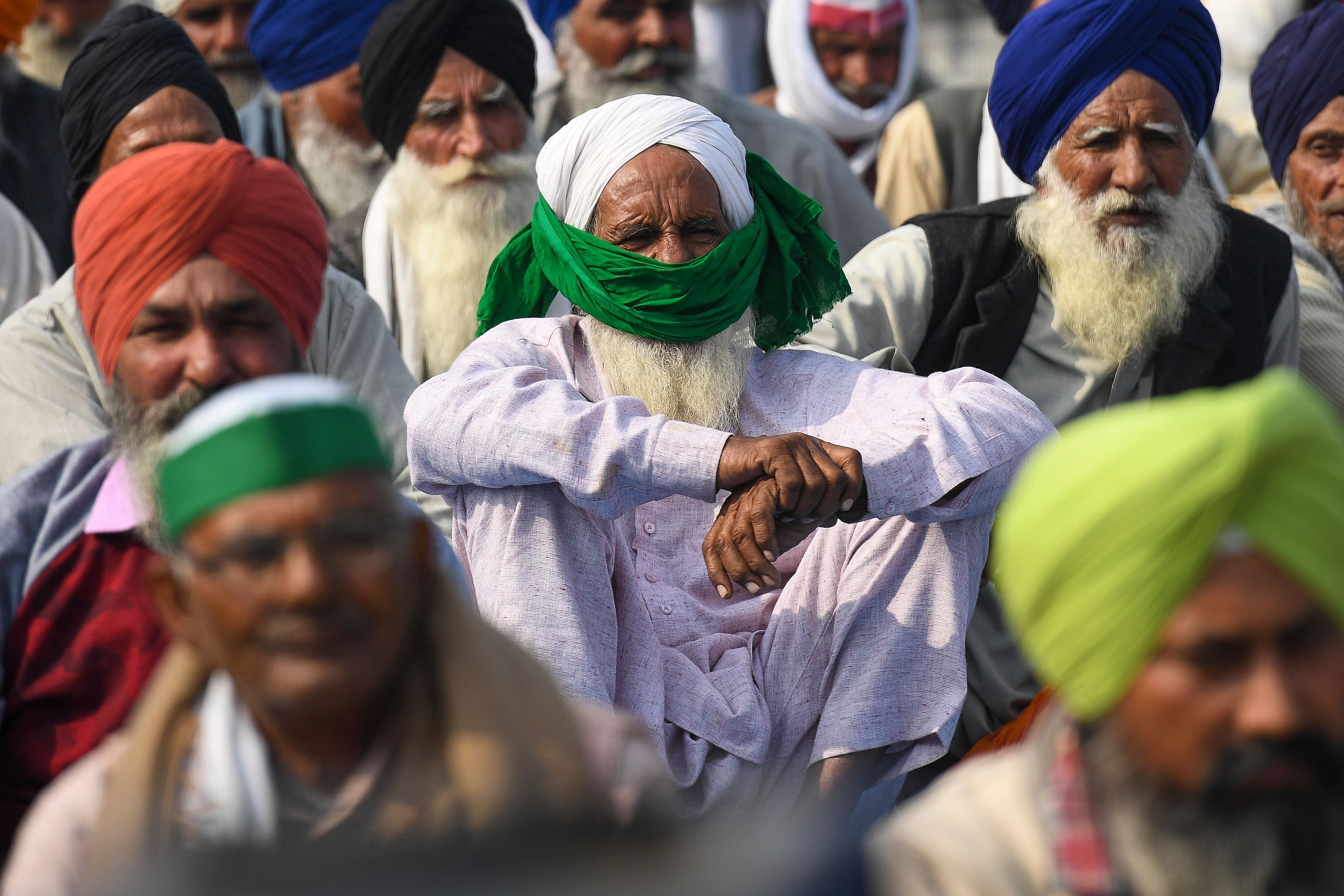 Farmers listen a speech along a highway blocked by police with barricades to stop farmers from marching to New Delhi to protest against the central government's recent agricultural reforms at the Delhi-Uttar Pradesh state border in Ghazipur on December 6, 2020. Credit: AFP Photo