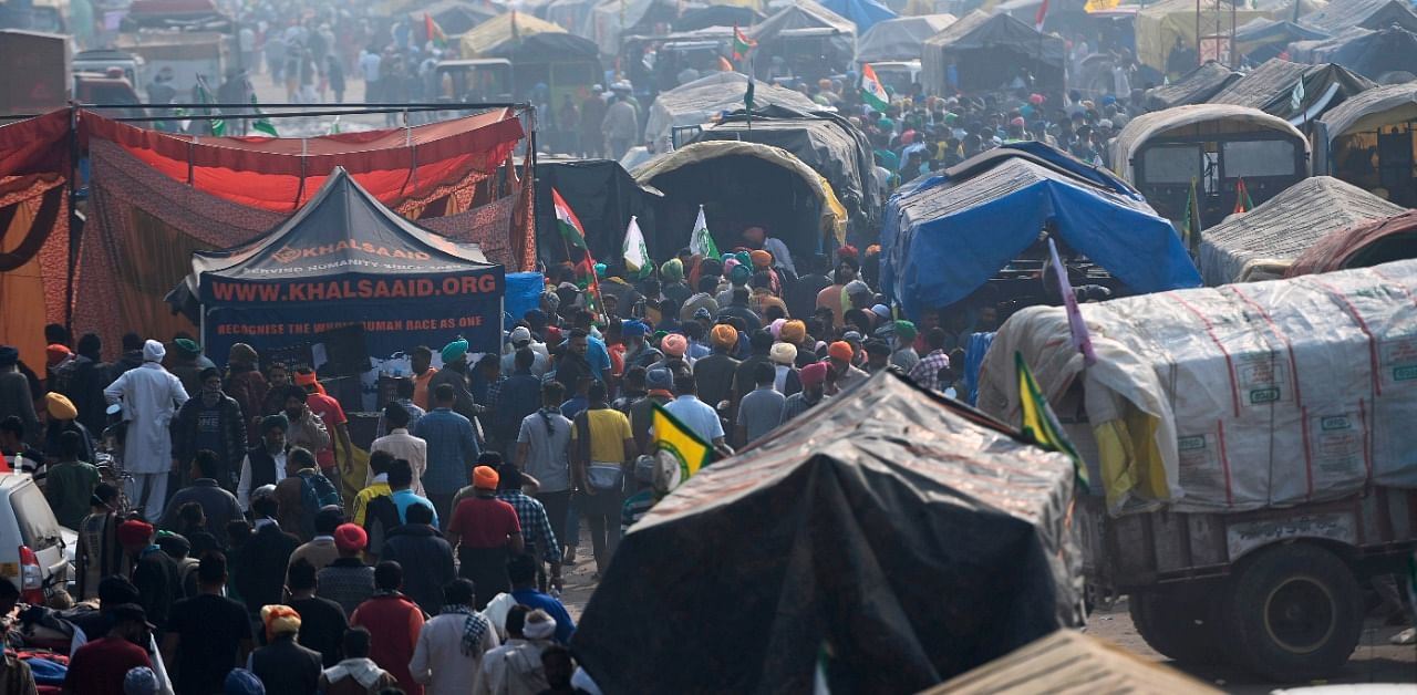 In this picture taken on December 5, 2020 farmer gather along a road blocked by police to stop farmers from marching to New Delhi to protest against the central government's recent agricultural reforms, at the Delhi-Haryana state border in Kundli. Credit: AFP Photo