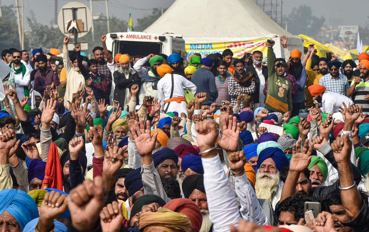 Farmers have food (langar) during their ongoing 'Delhi Chalo' agitation against the new farm laws, at Singhu border in New Delhi. Credit: PTI Photo.