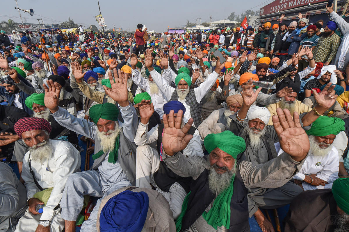 Farmers raise slogans during their agitation against the Center's new farm laws, at Singhu border in New Delhi. Credit: PTI Photo. 