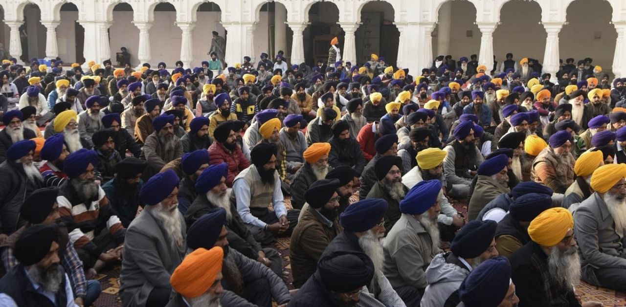 Shiromani Gurdwara Parbandhak Committee (SGPC) members and workers offer prayers in support of farmers protesting against the recent agricultural reforms, at the Golden Temple. Credit: AFP Photo