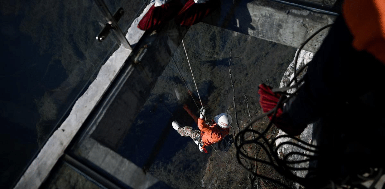A cleaner abseiling from a glass skywalk to collect litter at Tianmen mountain in Zhangjiajie, China's Hunan province. Credit: AFP Photo