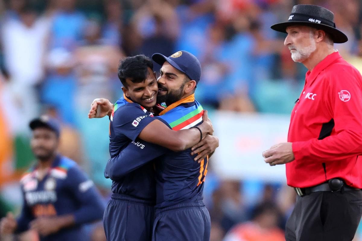 Virat Kohli (C) gives a hug to paceman Thangarasu Natarajan for his wicket of Australia's batsman D'Arcy Short during the second T20 cricket match between India and Australia at the Sydney Cricket Ground. Credit: AFP photo. 