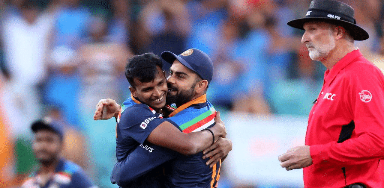 India's captain Virat Kohli (C) gives a hug to paceman Thangarasu Natarajan. Credit: AFP Photo