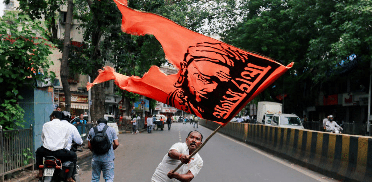 A man waves a flag as he blocks a road during a protest, organised by Maharashtra state's Maratha community, to press their demands for reserved quotas in government jobs and college places for students in Mumbai, India July 25, 2018. Credit: Reuters Photo