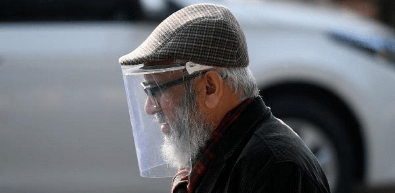 A man wearing a face shield as a preventive measure against the Covid-19 coronavirus walks along a street in Islamabad. Credit: AFP