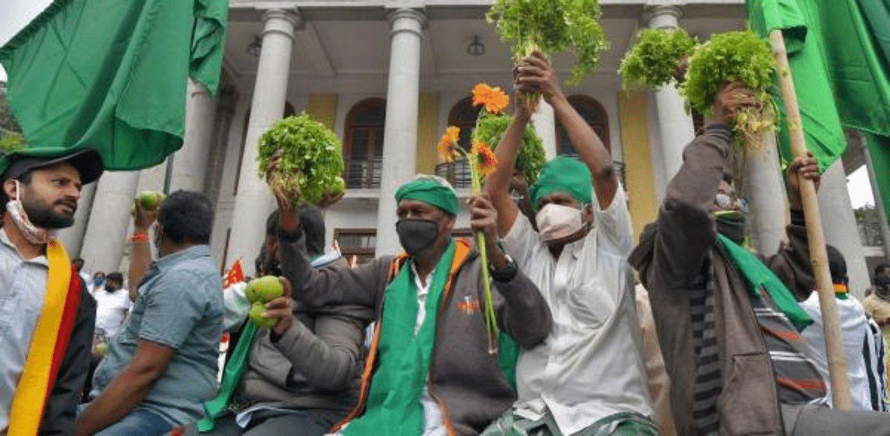 Activists supporting farmers hold agriculture produce take part in a protest called by farmers against the recent agricultural reforms in Bangalore. Credit: PTI