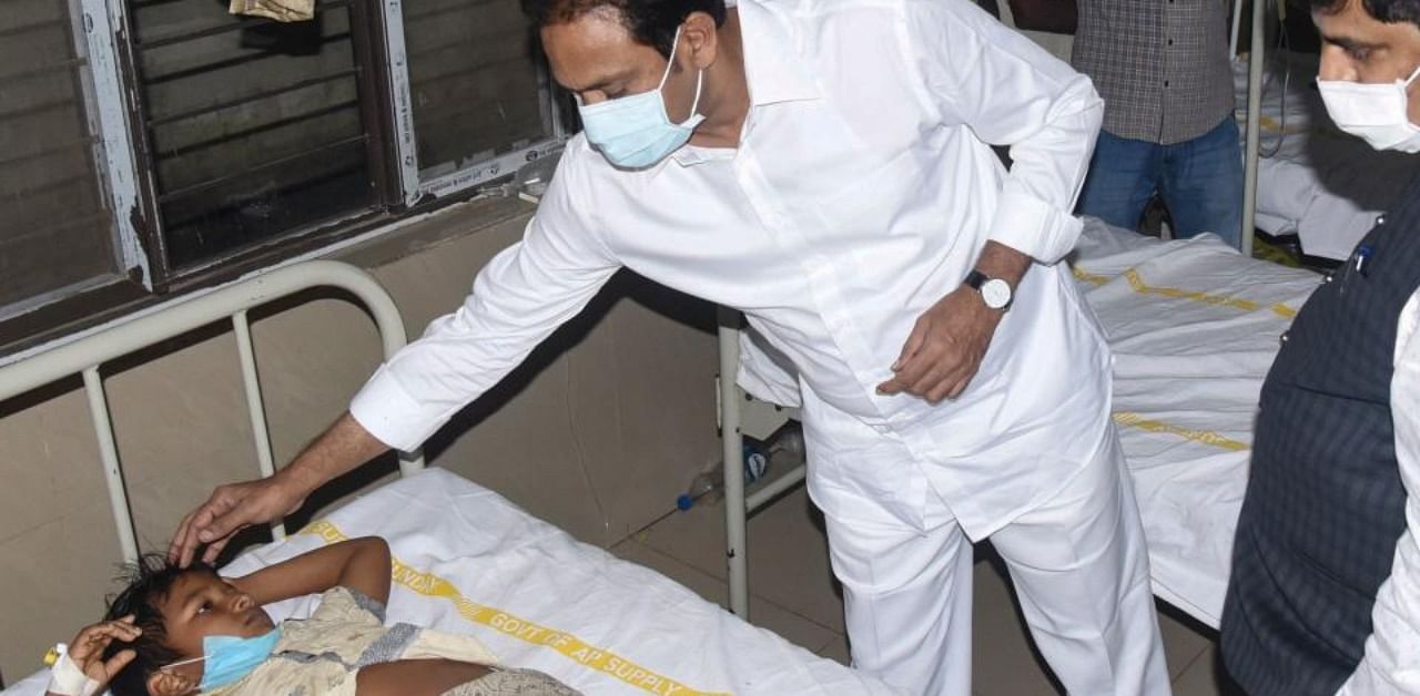 In this handout photo take and released by Public Relation Department Governement of Andhra Pradesh on December 6, 2020 Andrha Pradesh Health minister Alla Nani (C) visits patients receiving medical care for a mystery illness at a goverment hospital in Eluru. Credit: AFP Photo
