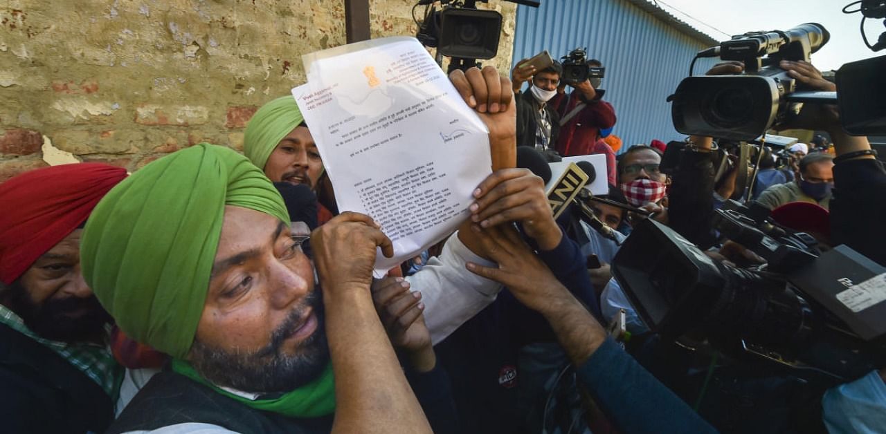 A representative of a farmer organisation shows a government proposal after a meeting on the Centre's farm reform laws. Credit: PTI Photo