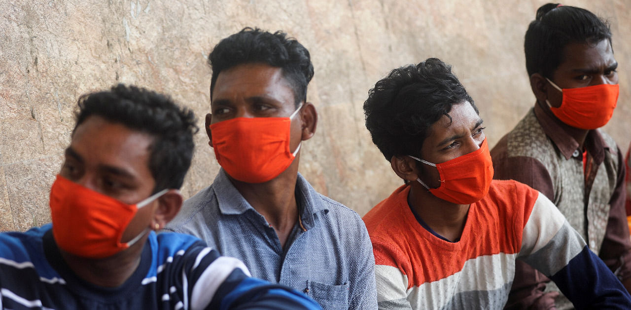 Men wearing protective masks wait to get tested during a rapid antigen testing campaign for the coronavirus disease in Mumbai. Credit: Reuters Photo