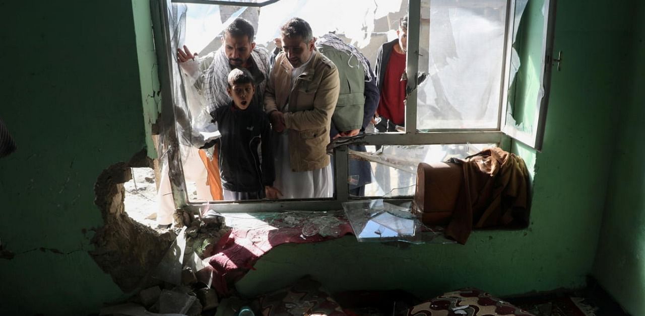 Afghan men look at the site of a rocket attack at a residential house in Kabul. Credit: Reuters photo.