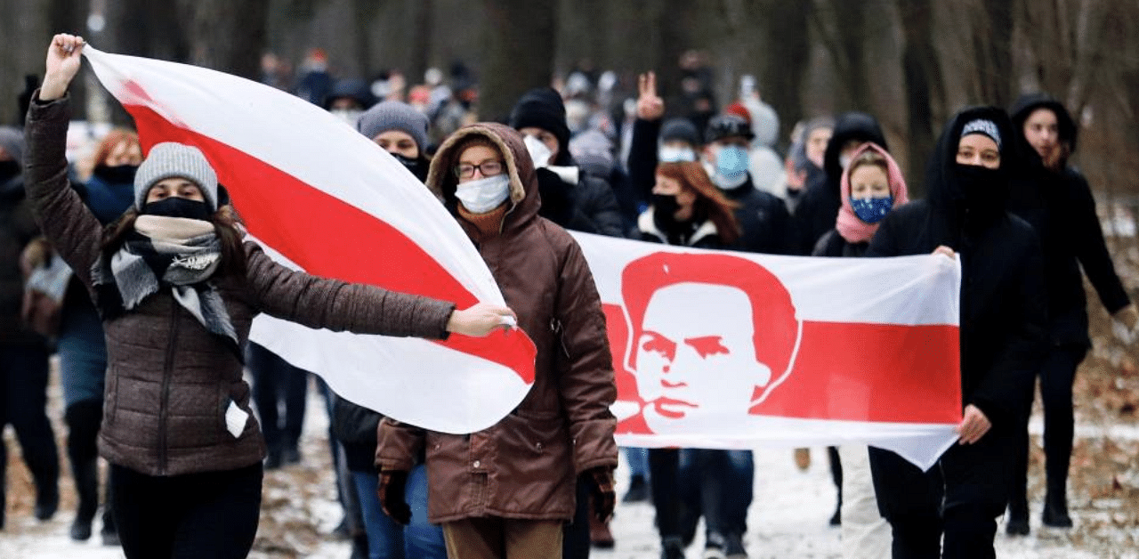 Opposition supporters carrying former white-red-white flags of Belarus parade through the streets during a rally against the Belarus presidential election results in Minsk, on December 13, 2020. Credit: AFP Photo