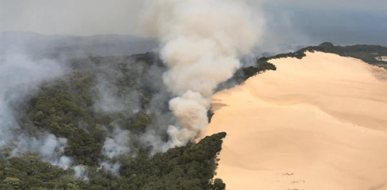 An aerial view shows smoke following a massive bushfire in Australia's Fraser Island. Fraser Island, the world's largest sand island, is now under the flood warning, which includes urging drivers to avoid roads where waters were already rising. Credit: Reuters