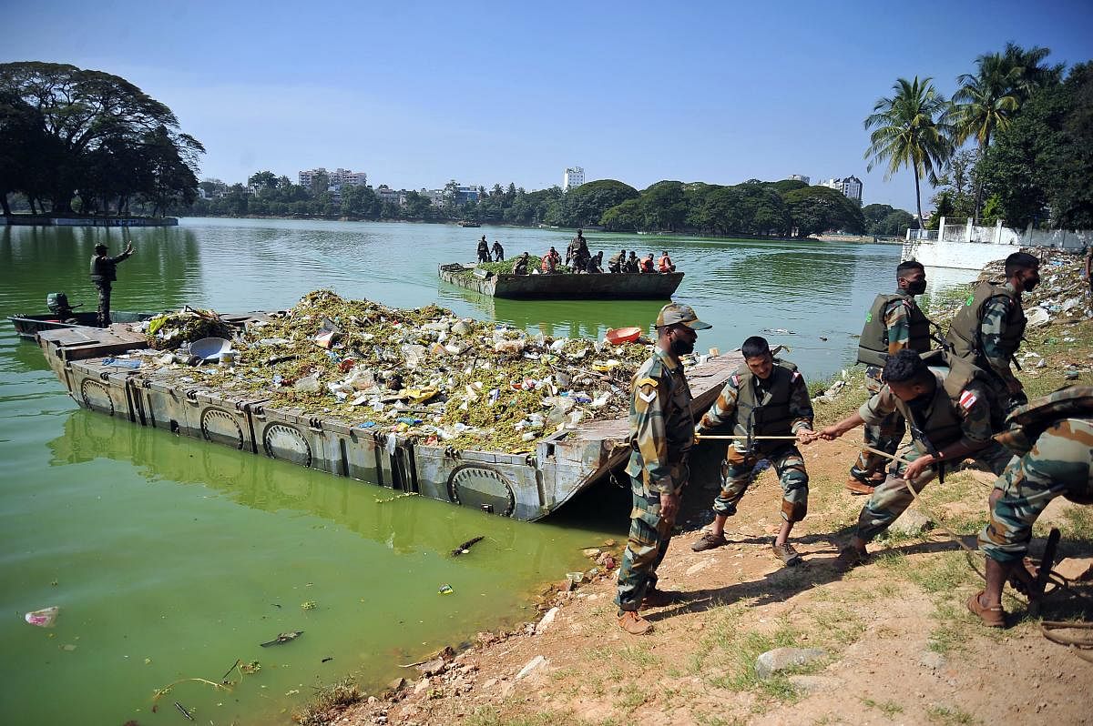 Sappers from MEG along with BBMP personnel pull in weeds and waste collected during the clean-up drive at Ulsoor Lake on Saturday. DH PHOTO/Pushkar V