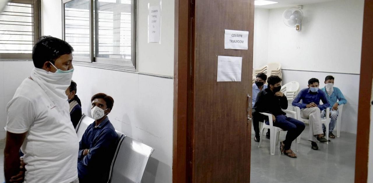 People wait outside a Covaxin trial room at a government hospital in Ahmedabad. Credit: PTI photo.
