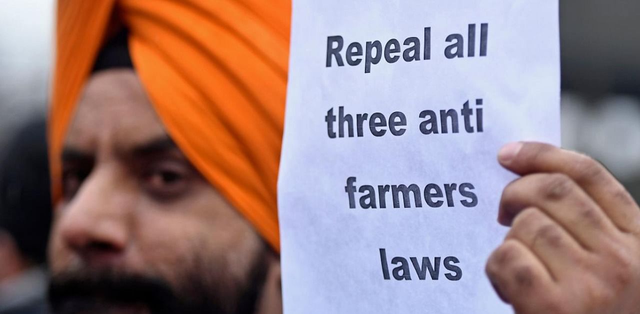 An activist from United Sikh Forum holds a placard in support of a nationwide general strike called by farmers to protest against the recent agricultural reforms in Srinagar. Credit: AFP file photo.